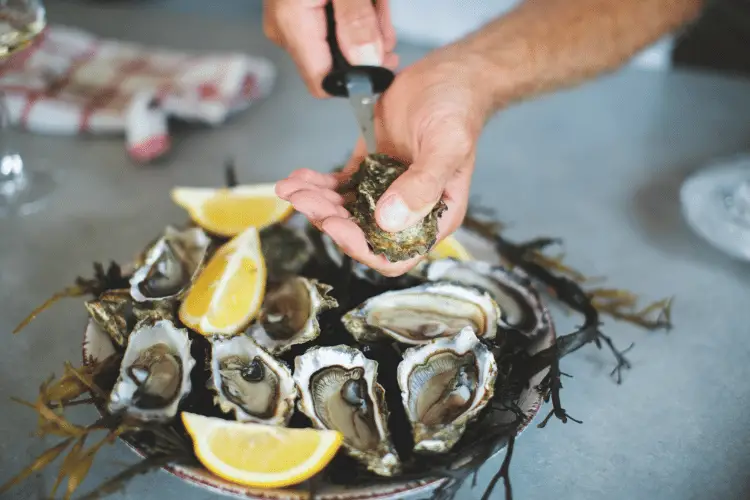 Close-up of a man opening an oyster